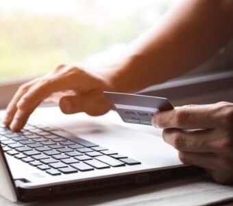 Laptop user entering credit card details